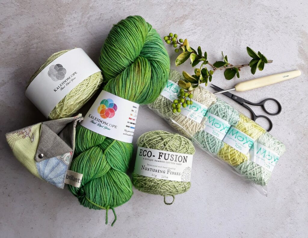 Assorted yarns and crochet tools arranged on a flat surface for a crafting session.