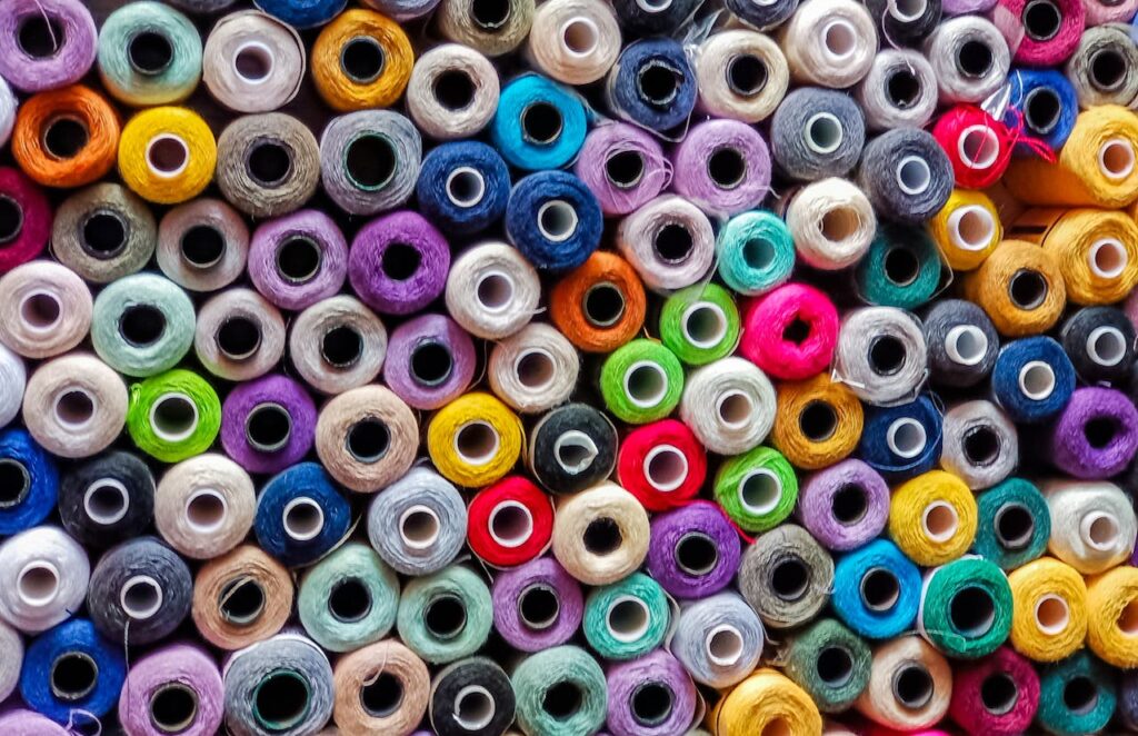 A vibrant collection of colorful thread spools organized in a closely packed pattern.